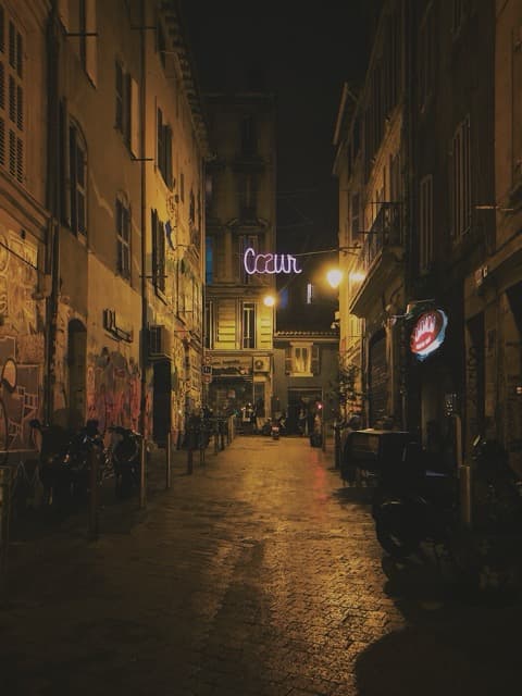 Parisian street at night with warm glow - cities that haunt you